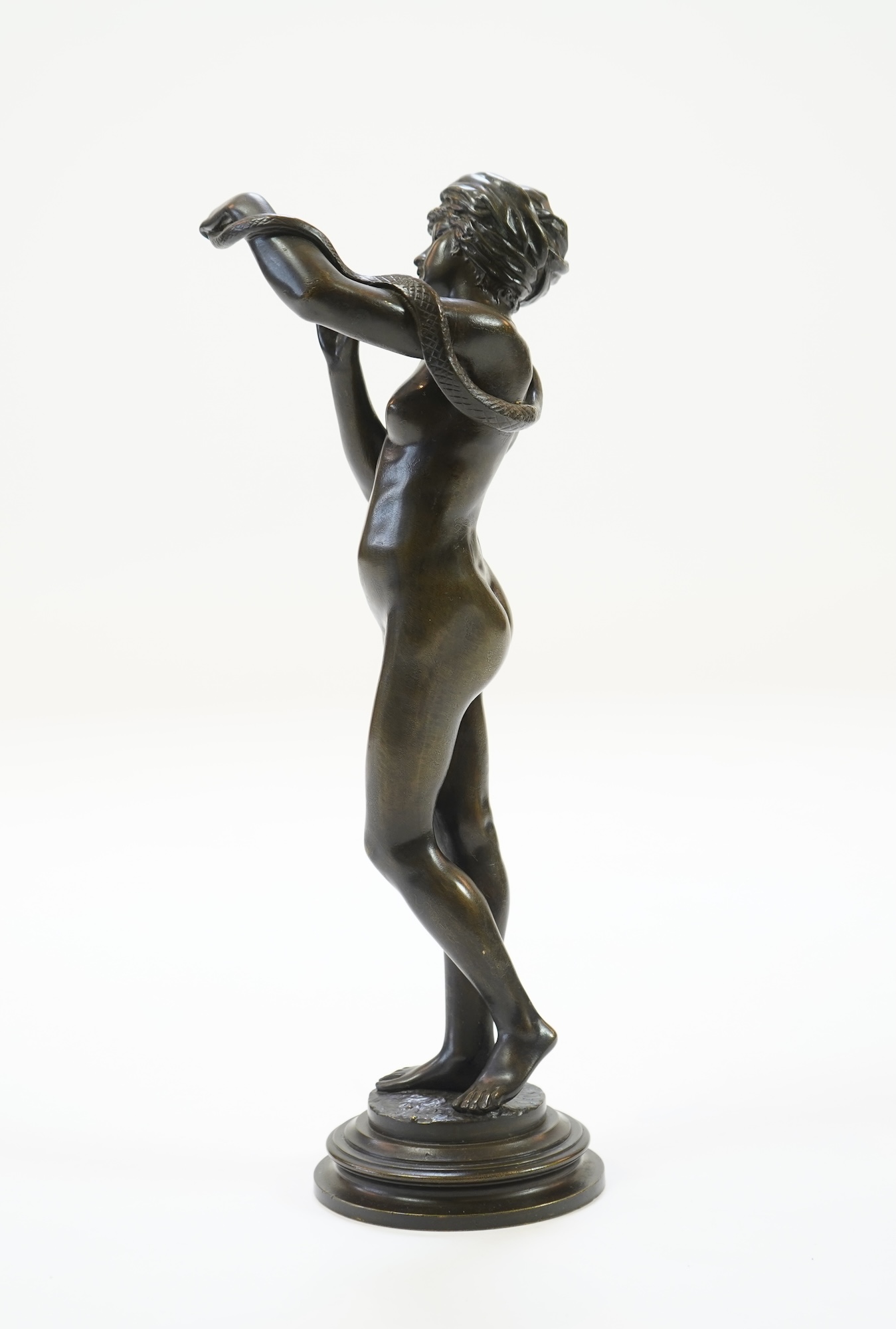 Josef Wind (German, 1864-1889). A patinated bronze of a nude female snake charmer